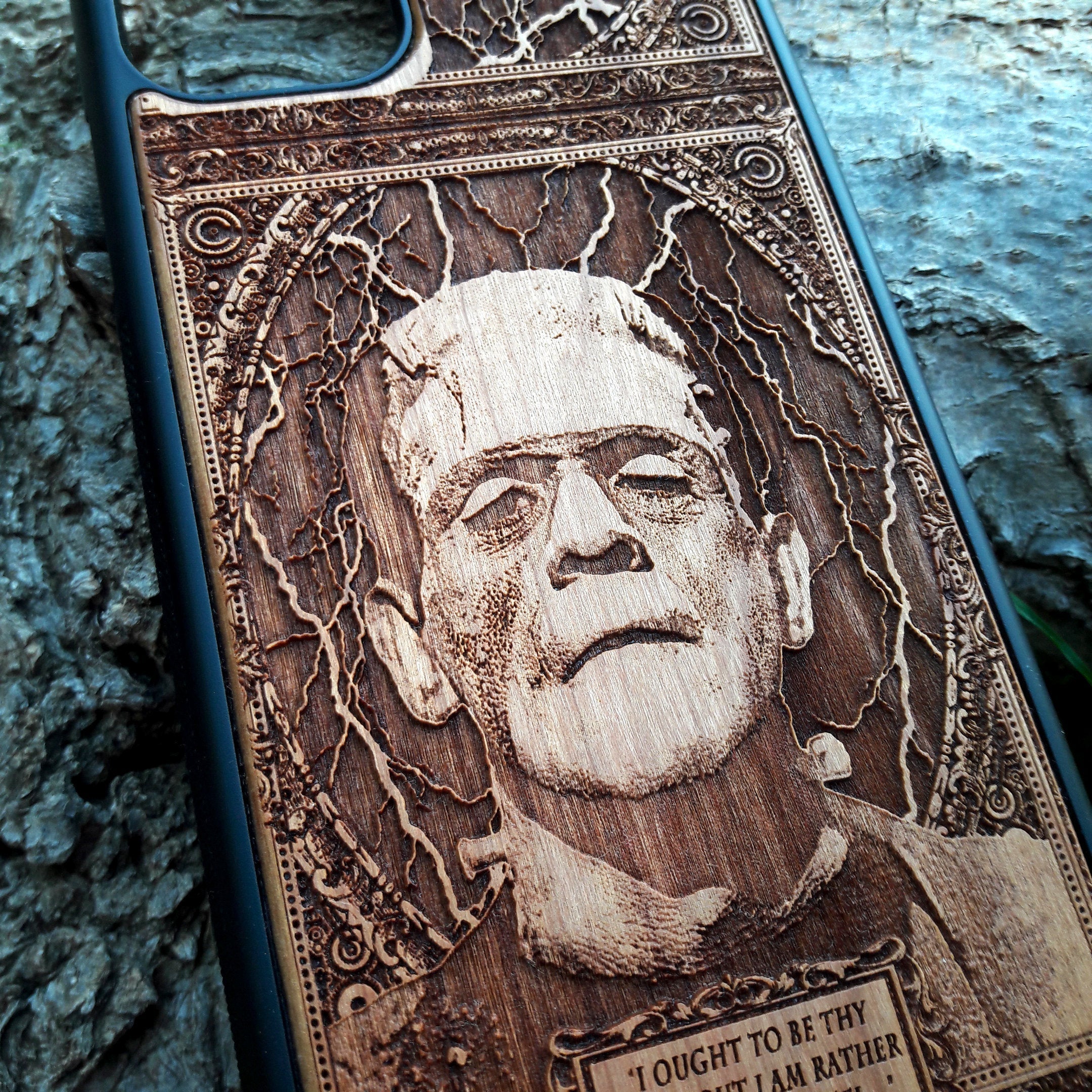 Wooden phone case with intricate carving of Frankenstein’s face and a classic quote: ‘I ought to be thy Adam, but I am rather the fallen angel...’ Designed for iPhone 16, Samsung Galaxy S25. Perfect for classic horror fans and vintage collectors.