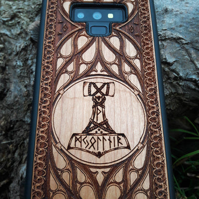 Eco friendly wood phone case carved with a beautiful carved Mjolnir the Hammer of Thor design. Quality sustainable wooden handcrafted and laser engraved covers.Available for: iPhone 11,12,13,14 Pro Max, Mini, Plus and Samsung Galaxy S20, S21, S22, Plus, Ultra, Note 20, Note 10