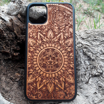 Intricately engraved wooden phone case featuring an Aztec calendar design with ornate details, crafted for durability and style. Compatible with iPhone  and Samsung Galaxy S models, this case combines cultural artistry with premium protection for your device.