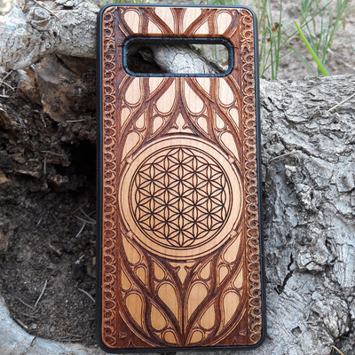 Wooden phone case featuring an intricate laser-engraved Flower of Life design, surrounded by detailed Gothic patterns. Slim, durable, and compatible with iPhone , 15, 14, 13, 12, 11 Pro Max Mini, and Samsung Galaxy S, S24, S23, S22, S21, S20 Ultra Plus, and Note 20. Perfect for those who love sacred geometry and unique craftsmanship.