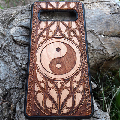 Wooden phone case with a laser-engraved Yin Yang symbol surrounded by a detailed Gothic pattern. Slim, durable, and designed for iPhone , 15, 14, 13, 12, 11 Pro Max Mini and Samsung Galaxy S, S24, S23, S22, S21, S20 Ultra Plus, Note 20. Ideal for those who appreciate balance and spiritual symbols in their phone accessories.
