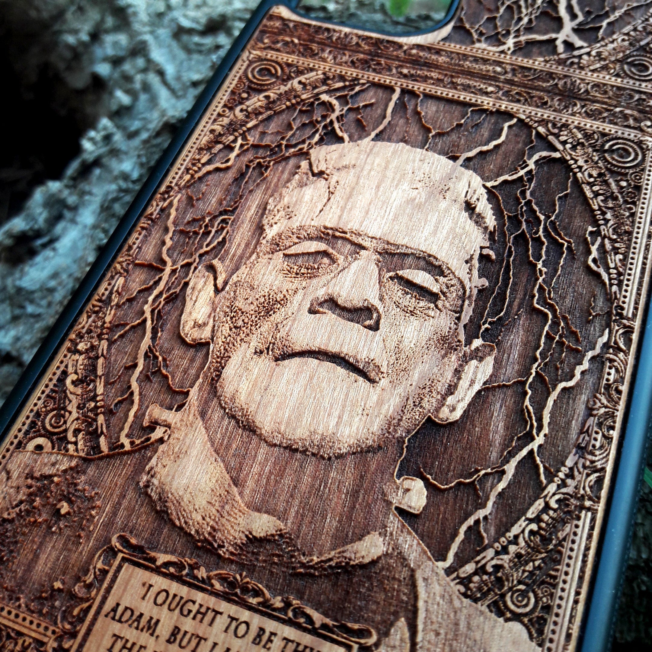 Wooden phone case with intricate carving of Frankenstein’s face and a classic quote: ‘I ought to be thy Adam, but I am rather the fallen angel...’ Designed for iPhone 16, Samsung Galaxy S25. Perfect for classic horror fans and vintage collectors.