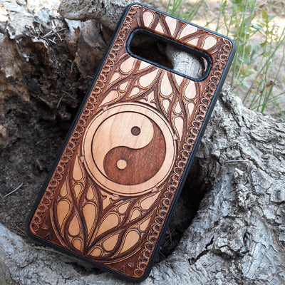 Wooden phone case with a laser-engraved Yin Yang symbol surrounded by a detailed Gothic pattern. Slim, durable, and designed for iPhone , 15, 14, 13, 12, 11 Pro Max Mini and Samsung Galaxy S, S24, S23, S22, S21, S20 Ultra Plus, Note 20. Ideal for those who appreciate balance and spiritual symbols in their phone accessories.