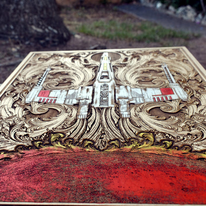 Close-up of detailed wood engraving of X-Wing fighter ship

