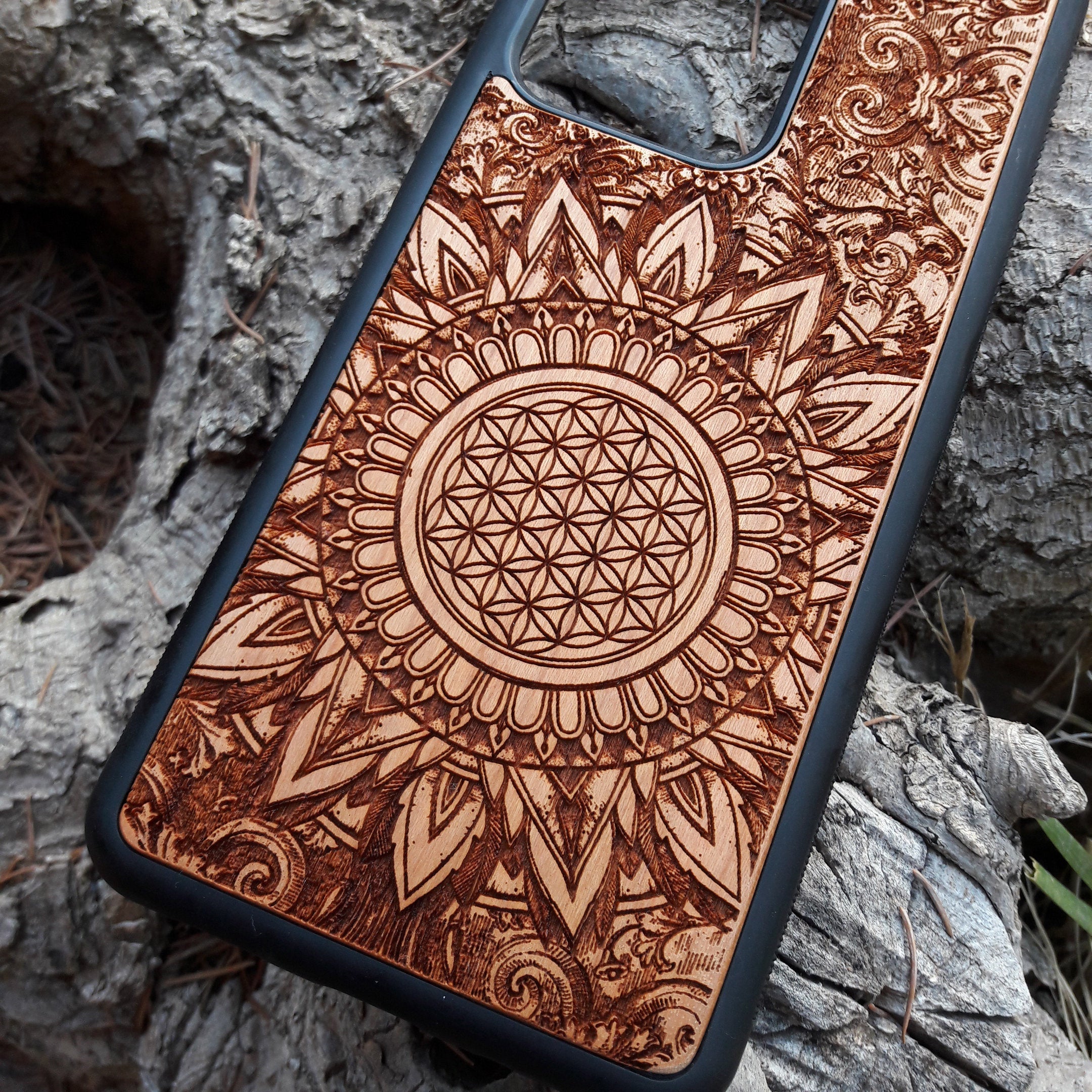 Wooden phone case featuring a detailed, laser-engraved Flower of Life design with intricate mandala patterns. Slim, durable, and compatible with iPhone 16, 15, 14, 13, 12, 11 Pro Max Mini and Samsung Galaxy S25, S24, S23, S22, S21, S20 Ultra Plus, Note 20. Perfect for those who appreciate sacred geometry and natural aesthetics.