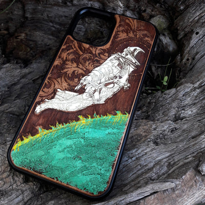Close-up of green planet artwork on hand-painted cherry wood phone case.