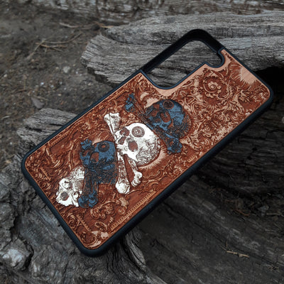 Laser-engraved skull design on a wooden phone case