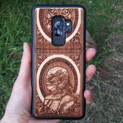Wooden phone case with intricate carving of the Creature from the Black Lagoon design, crafted for iPhone 16, Samsung Galaxy S25. Perfect for horror fans and collectors, offering premium protection and gothic style.