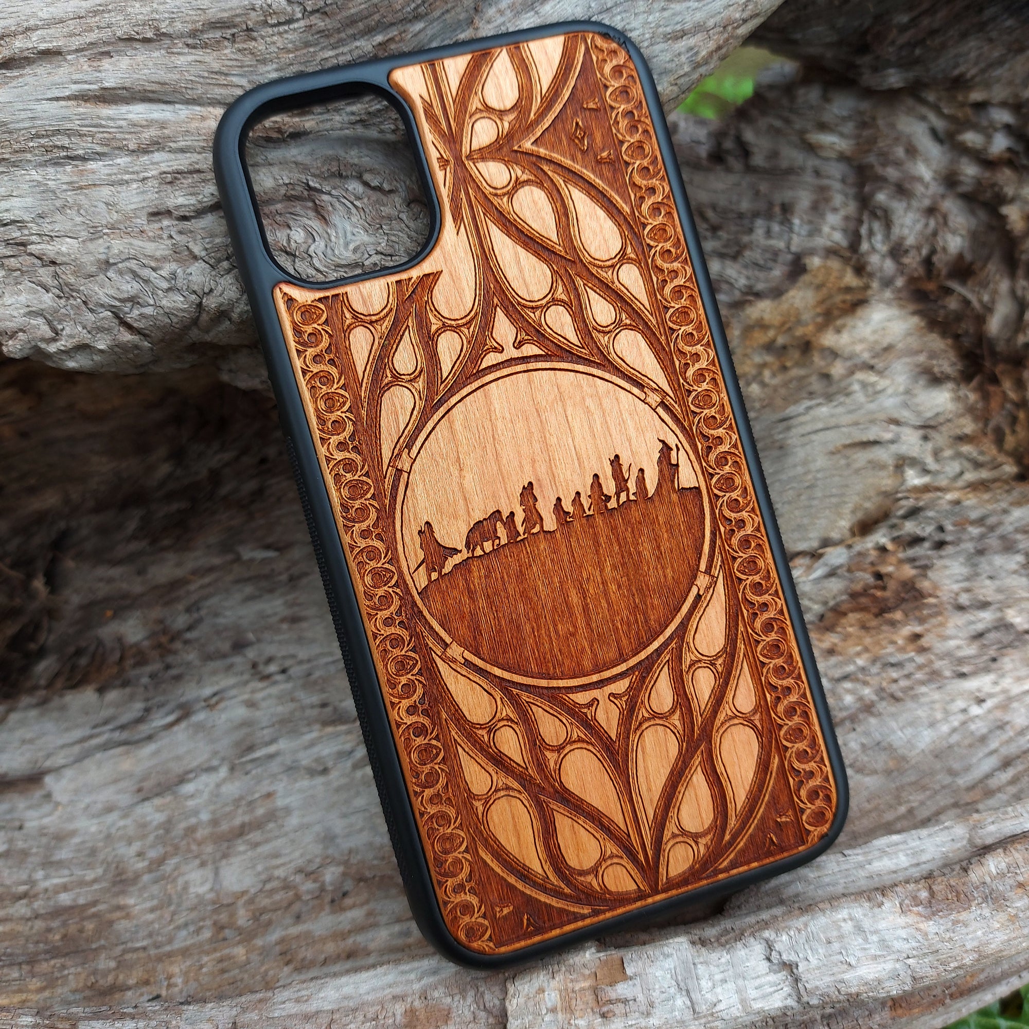 Lord of the Rings wood phone case featuring the Fellowship of the Ring silhouette and intricate Elvish-inspired patterns. Laser-engraved for detailed artistry and durability, this case is compatible with iPhone 16, 15, 14, 13, 12, 11, Pro Max, Mini, and Samsung Galaxy S25, S24, S23, S22, S21, S20 Ultra, Plus, Note 20. A stylish and protective accessory for Tolkien fans.
