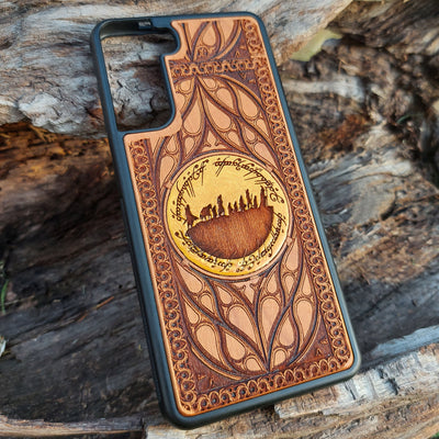 Hand-painted Lord of the Rings wood phone case featuring the Fellowship of the Ring silhouette surrounded by Elvish script and intricate patterns. The golden accent highlights the design, making it a unique and artistic piece. Laser-engraved for durability, this case is compatible with iPhone , 15, 14, 13, 12, 11, Pro Max, Mini, and Samsung Galaxy S, S24, S23, S22, S21, S20 Ultra, Plus, Note 20. A perfect accessory for Tolkien fans seeking style and protection.
