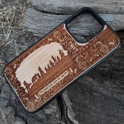 Lord of the Rings wood phone case featuring the Fellowship of the Ring silhouette, ornate border designs, and the engraved quote 'The Road Goes Ever On And On.' Laser-engraved for intricate detailing and crafted for durability, this case is compatible with iPhone , 15, 14, 13, 12, 11, Pro Max, Mini, and Samsung Galaxy S, S24, S23, S22, S21, S20 Ultra, Plus, Note 20. A perfect accessory for Tolkien fans seeking style and protection.