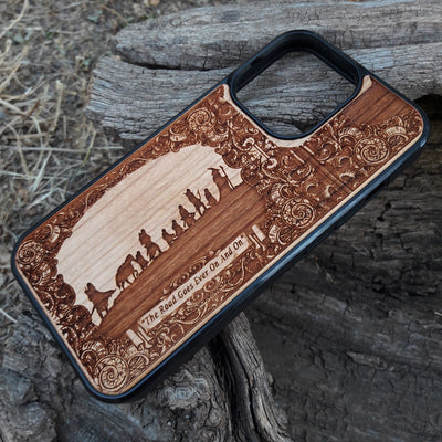 Lord of the Rings wood phone case featuring the Fellowship of the Ring silhouette, ornate border designs, and the engraved quote 'The Road Goes Ever On And On.' Laser-engraved for intricate detailing and crafted for durability, this case is compatible with iPhone , 15, 14, 13, 12, 11, Pro Max, Mini, and Samsung Galaxy S, S24, S23, S22, S21, S20 Ultra, Plus, Note 20. A perfect accessory for Tolkien fans seeking style and protection.