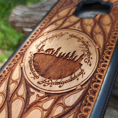 Lord of the Rings wood phone case featuring the Fellowship of the Ring silhouette surrounded by Elvish script and intricate, elegant patterns. Laser-engraved for precision and durability, this case is compatible with iPhone , 15, 14, 13, 12, 11, Pro Max, Mini, and Samsung Galaxy S, S24, S23, S22, S21, S20 Ultra, Plus, Note 20. A unique and protective accessory for Tolkien fans.