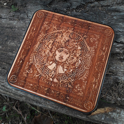Overhead view of Medusa-inspired dark art on wooden charger.