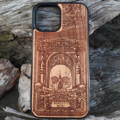 Laser-engraved Memento Mori wood phone case featuring a skull, crossbones, and intricate Gothic patterns with "Memento Mori" text for iPhone  and Samsung Galaxy S. Perfect for Gothic and philosophical design lovers.