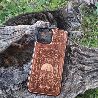 Laser-engraved Memento Mori wood phone case featuring a skull, crossbones, and intricate Gothic patterns with "Memento Mori" text for iPhone  and Samsung Galaxy S. Perfect for Gothic and philosophical design lovers.