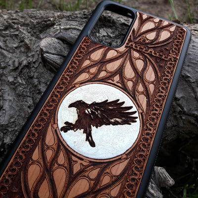 Handcrafted wood phone case with intricate raven design. Compatible with iPhone 15, 14, 13, 12, 11 Pro Max Mini and Samsung Galaxy S24, S23, S22, S21, S20 Ultra Plus Note. Durable, slim, and unique—order now!