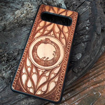 Eco friendly wood phone case carved with a beautiful Ouroboros design. Celtic Triskelion Spiral wood phone case with laser-engraved design for iPhone & Samsung Galaxy. Compatible with iPhone , 15, 14, 13, 12, 11 Pro Max Mini & Samsung Galaxy S, S24, S23, S22, S21, S20 Ultra Plus Note 20. Unique and durable.