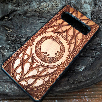 Eco friendly wood phone case carved with a beautiful Ouroboros design. Celtic Triskelion Spiral wood phone case with laser-engraved design for iPhone & Samsung Galaxy. Compatible with iPhone , 15, 14, 13, 12, 11 Pro Max Mini & Samsung Galaxy S, S24, S23, S22, S21, S20 Ultra Plus Note 20. Unique and durable.