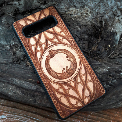 Eco friendly wood phone case carved with a beautiful Ouroboros design. Celtic Triskelion Spiral wood phone case with laser-engraved design for iPhone & Samsung Galaxy. Compatible with iPhone , 15, 14, 13, 12, 11 Pro Max Mini & Samsung Galaxy S, S24, S23, S22, S21, S20 Ultra Plus Note 20. Unique and durable.