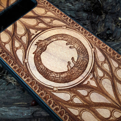 Eco friendly wood phone case carved with a beautiful Ouroboros design. Celtic Triskelion Spiral wood phone case with laser-engraved design for iPhone & Samsung Galaxy. Compatible with iPhone , 15, 14, 13, 12, 11 Pro Max Mini & Samsung Galaxy S, S24, S23, S22, S21, S20 Ultra Plus Note 20. Unique and durable.