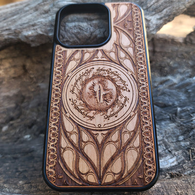 Lord of the Rings wood phone case featuring the Eye of Sauron surrounded by Elvish script and intricate, elegant patterns. Laser-engraved for durability and unique artistry, this case is compatible with iPhone , 15, 14, 13, 12, 11, Pro Max, Mini, and Samsung Galaxy S, S24, S23, S22, S21, S20 Ultra, Plus, Note 20. A stunning and protective accessory for Tolkien fans.
