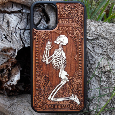 Hand-painted wooden phone case featuring a laser-engraved gothic praying skeleton design on cherrywood. Compatible with iPhone -11 Pro Max and Galaxy S-S20 models.