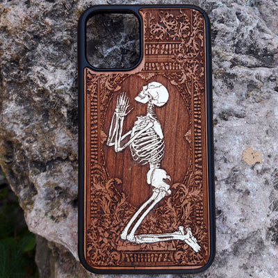 Hand-painted wooden phone case featuring a laser-engraved gothic praying skeleton design on cherrywood. Compatible with iPhone -11 Pro Max and Galaxy S-S20 models.