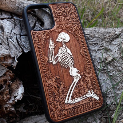 Hand-painted wooden phone case featuring a laser-engraved gothic praying skeleton design on cherrywood. Compatible with iPhone -11 Pro Max and Galaxy S-S20 models.