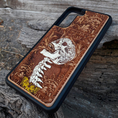 Gothic skull artwork engraved on a wooden phone case, compatible with iPhone and Samsung Galaxy