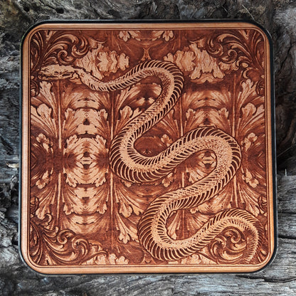 Wooden wireless charger with skeleton snake engraved dark art design.