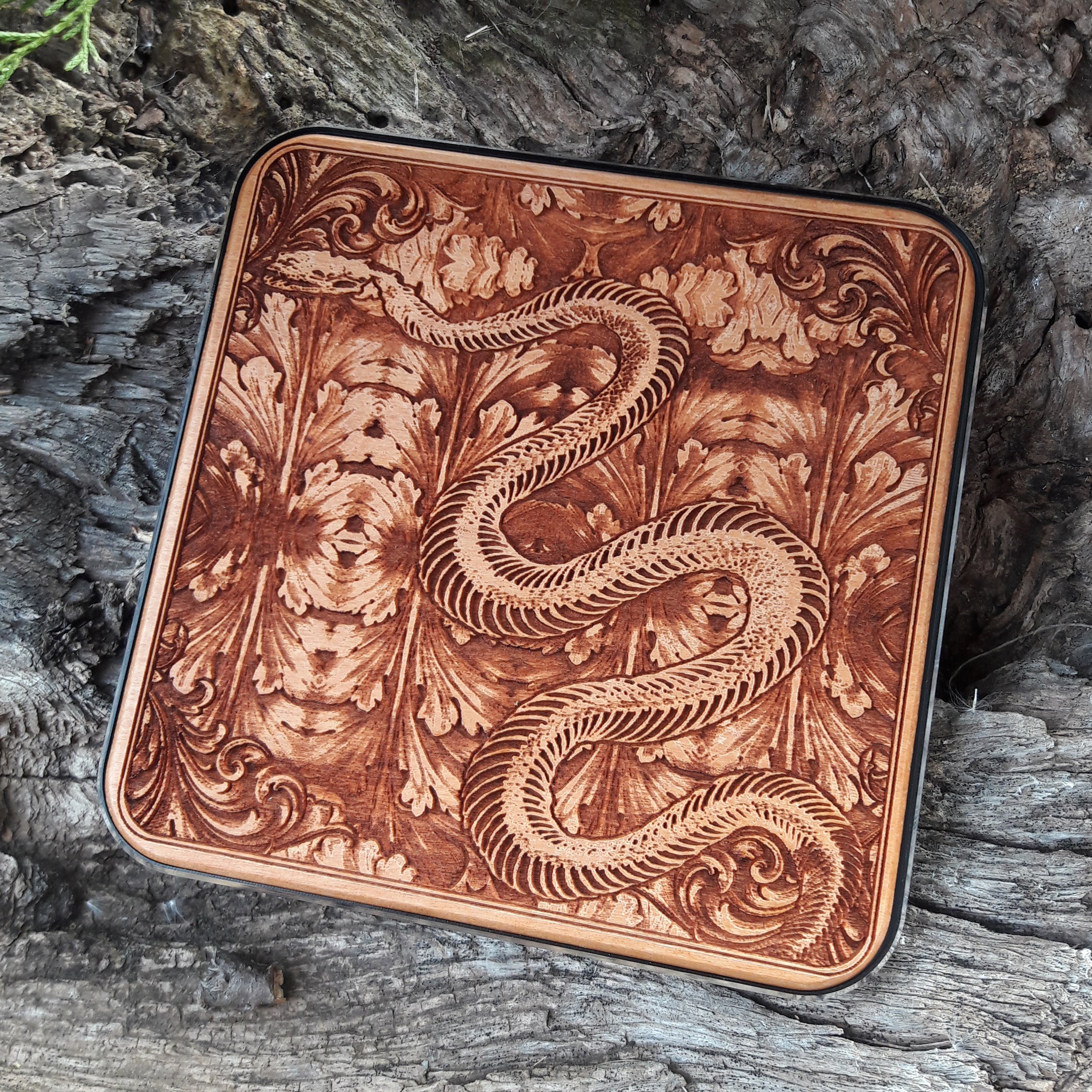 Side view of slim wood charger featuring gothic skeleton snake art.