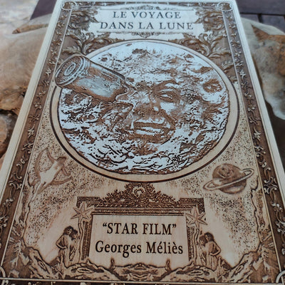 Iconic moon face scene from Le Voyage Dans La Lune engraved on wood