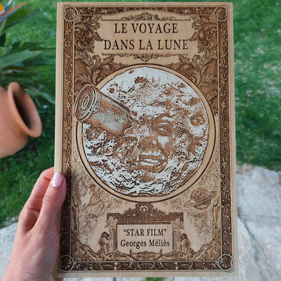 Engraved wooden artwork featuring Georges Méliès' moon face