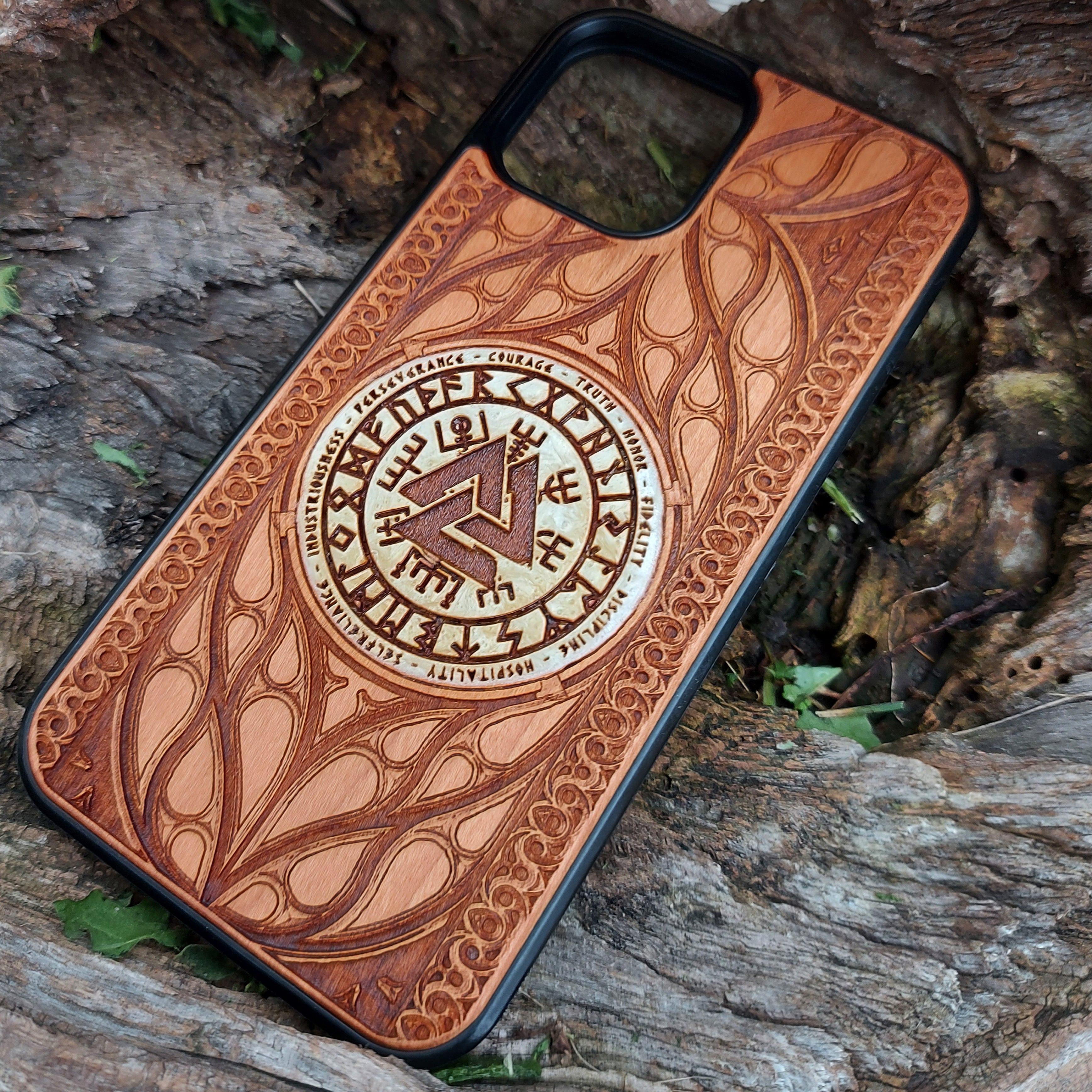 Nordic-inspired wooden phone case featuring a Valknut symbol surrounded by runic designs, precision-engraved for a bold and meaningful statement. This protective case is a perfect fit for iPhone 16, 15, 14, 13, 12, 11, Pro Max, Mini, and Samsung Galaxy S25, S24, S23, S22, S21, S20 Ultra, Plus, Note 20. Ideal for those who admire Norse mythology and elegant craftsmanship.