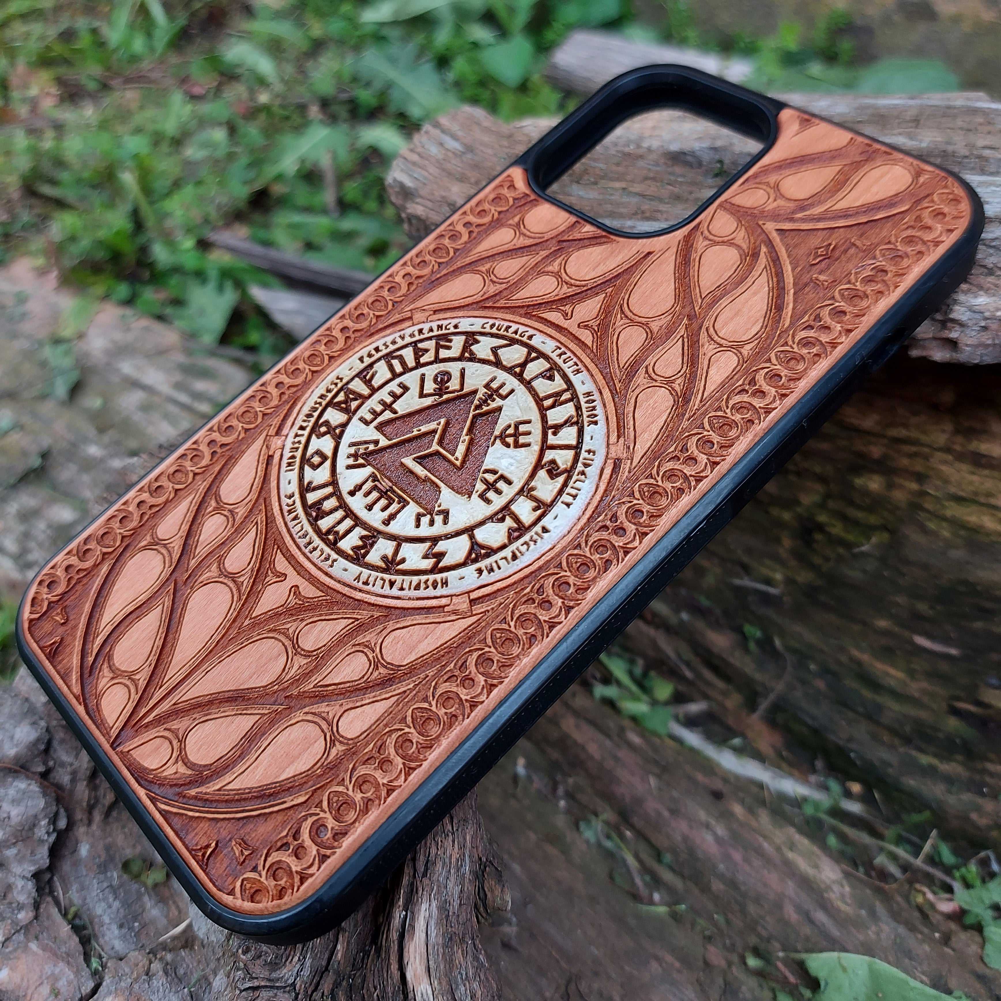 Nordic-inspired wooden phone case featuring a Valknut symbol surrounded by runic designs, precision-engraved for a bold and meaningful statement. This protective case is a perfect fit for iPhone 16, 15, 14, 13, 12, 11, Pro Max, Mini, and Samsung Galaxy S25, S24, S23, S22, S21, S20 Ultra, Plus, Note 20. Ideal for those who admire Norse mythology and elegant craftsmanship.