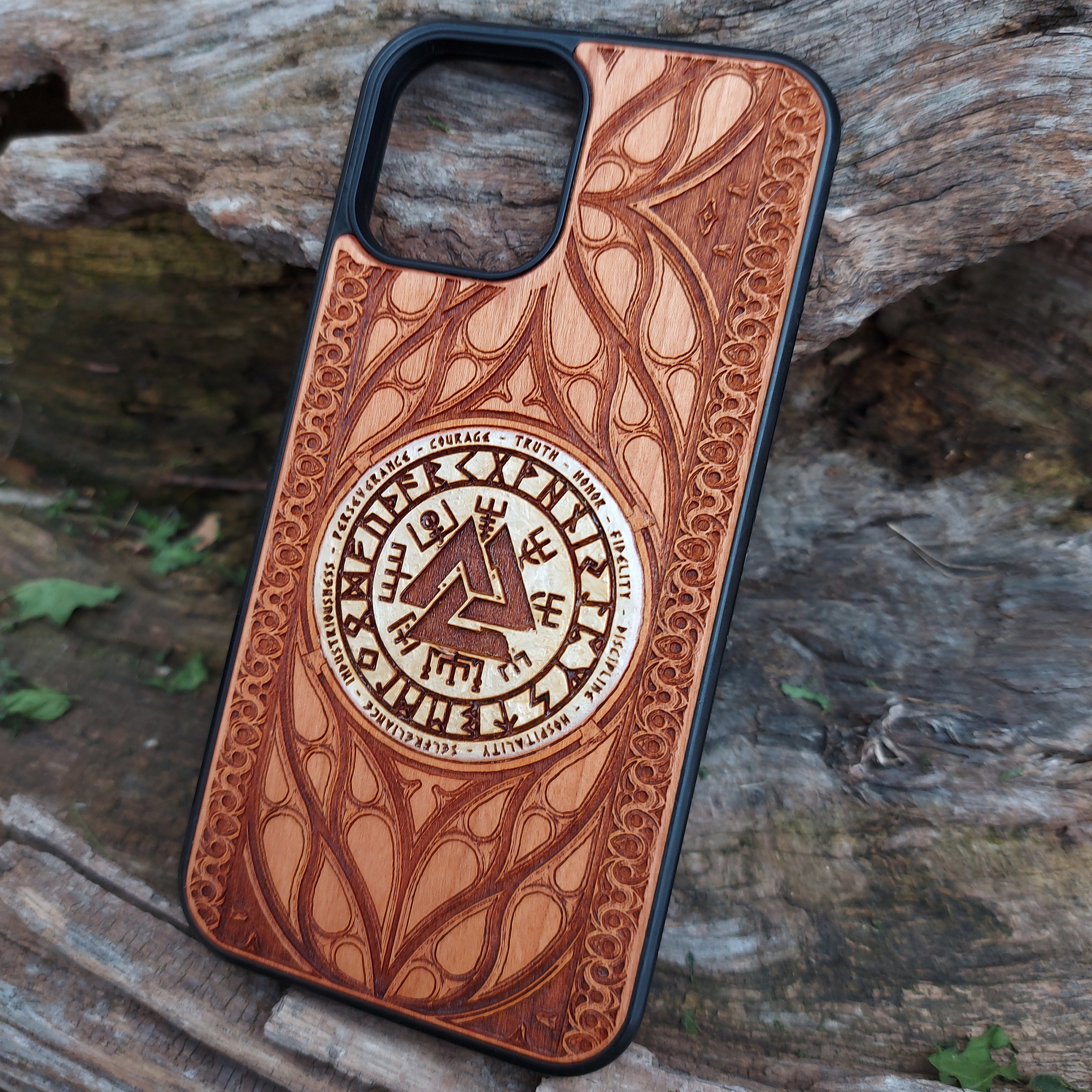 Nordic-inspired wooden phone case featuring a Valknut symbol surrounded by runic designs, precision-engraved for a bold and meaningful statement. This protective case is a perfect fit for iPhone 16, 15, 14, 13, 12, 11, Pro Max, Mini, and Samsung Galaxy S25, S24, S23, S22, S21, S20 Ultra, Plus, Note 20. Ideal for those who admire Norse mythology and elegant craftsmanship.