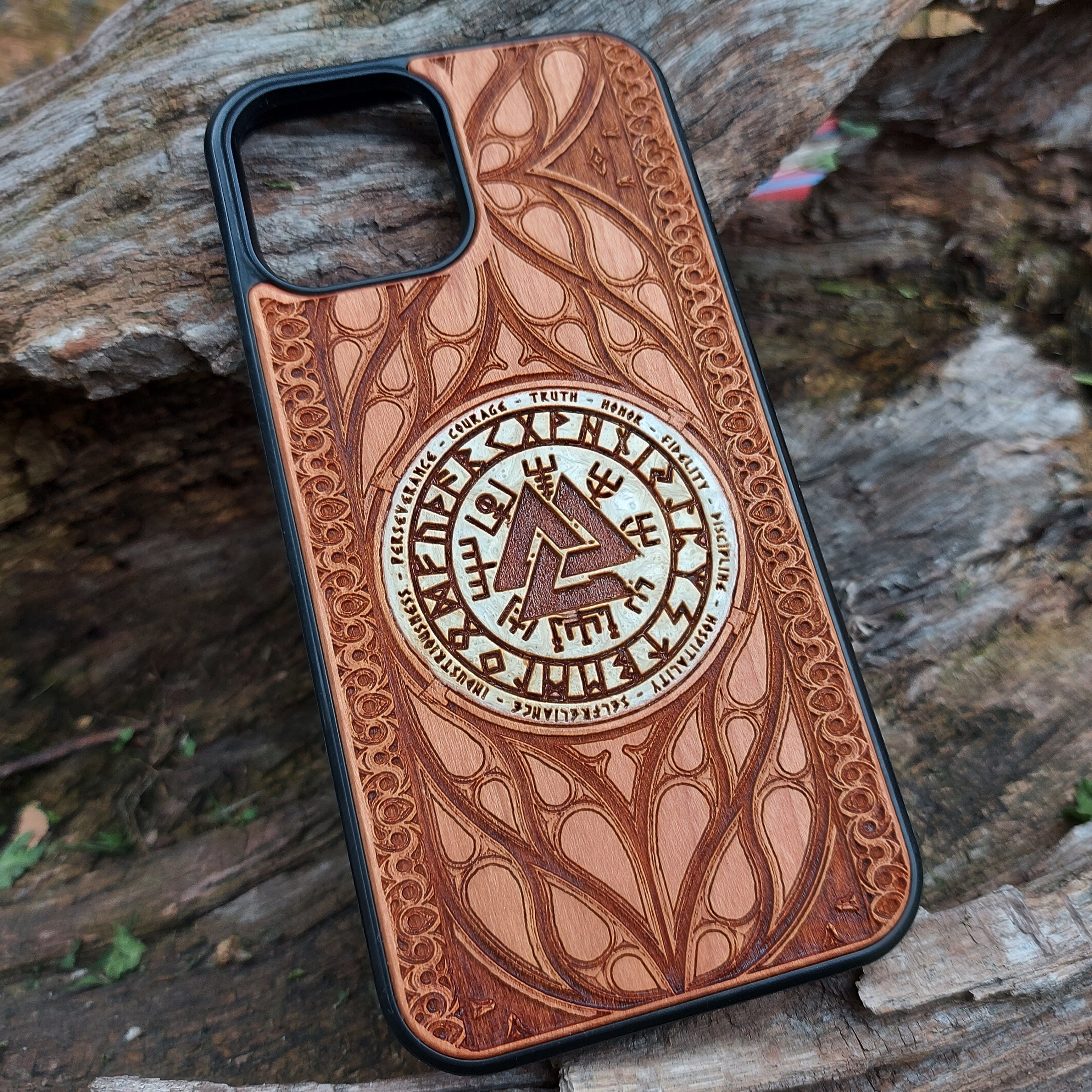 Nordic-inspired wooden phone case featuring a Valknut symbol surrounded by runic designs, precision-engraved for a bold and meaningful statement. This protective case is a perfect fit for iPhone 16, 15, 14, 13, 12, 11, Pro Max, Mini, and Samsung Galaxy S25, S24, S23, S22, S21, S20 Ultra, Plus, Note 20. Ideal for those who admire Norse mythology and elegant craftsmanship.