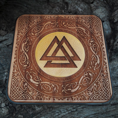 Close-up of Viking runes hand-painted on wooden wireless charger.