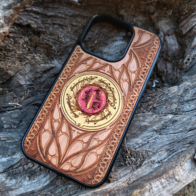 Hand-painted Lord of the Rings wood phone case featuring the Eye of Sauron with vibrant colors and laser-engraved Elvish script. Crafted with intricate detailing for durability and elegance, this case is compatible with iPhone , 15, 14, 13, 12, 11, Pro Max, Mini, and Samsung Galaxy S, S24, S23, S22, S21, S20 Ultra, Plus, Note 20. A unique and protective accessory for Tolkien fans.