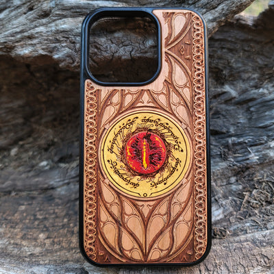 Hand-painted Lord of the Rings wood phone case featuring the Eye of Sauron with vibrant colors and laser-engraved Elvish script. Crafted with intricate detailing for durability and elegance, this case is compatible with iPhone , 15, 14, 13, 12, 11, Pro Max, Mini, and Samsung Galaxy S, S24, S23, S22, S21, S20 Ultra, Plus, Note 20. A unique and protective accessory for Tolkien fans.